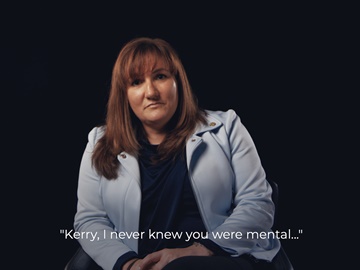 A woman is being interviewed in front of a black background 